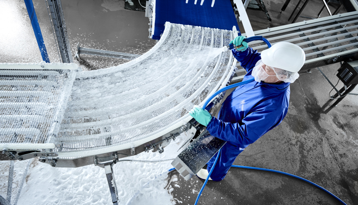 Operator using Foamico low pressure technology for conveyor cleaning 