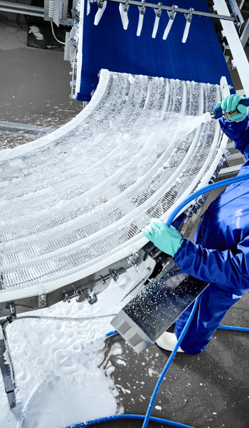 Operator using Foamico low pressure technology for conveyor cleaning 