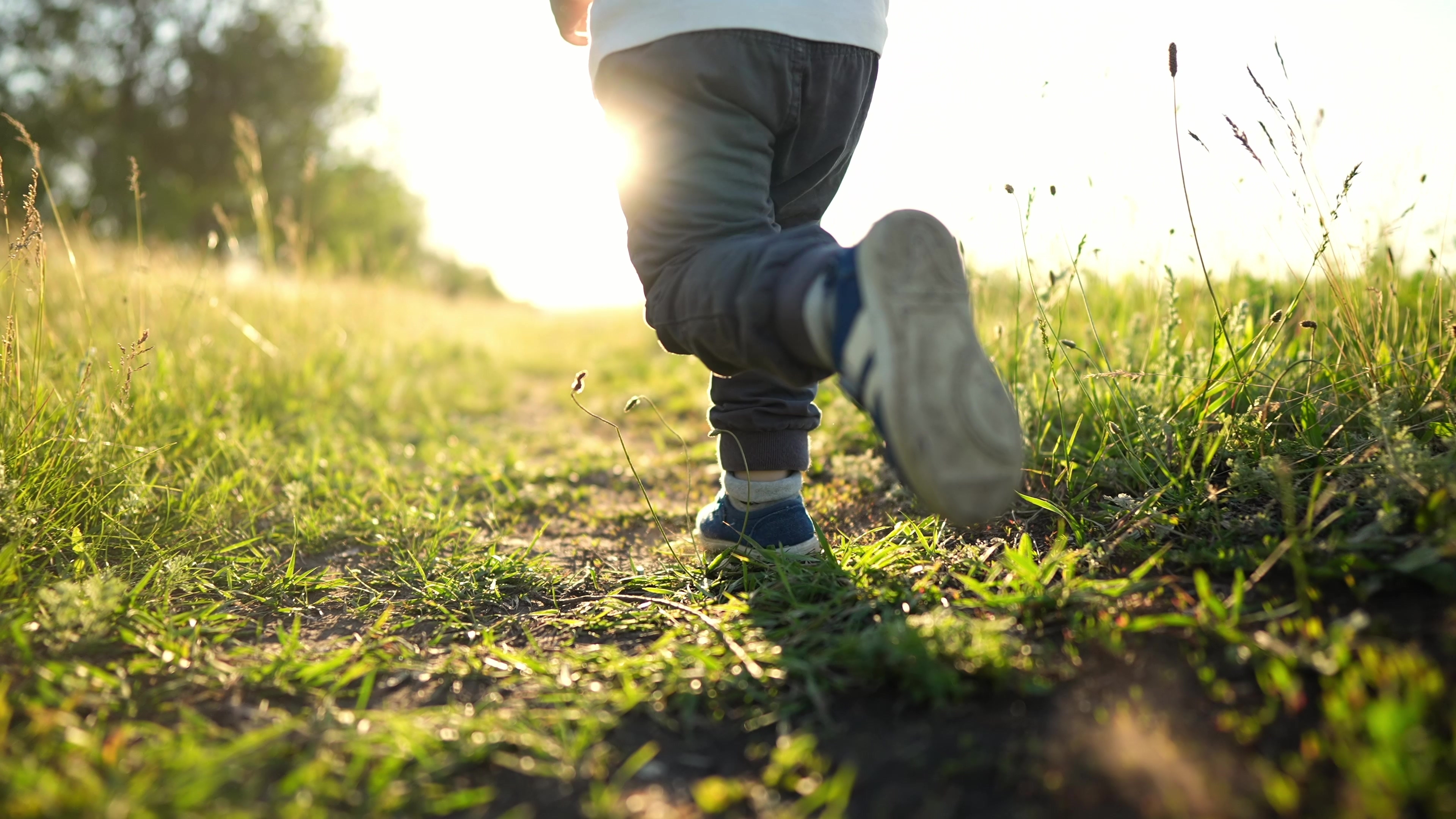 A child running through grass at sunset