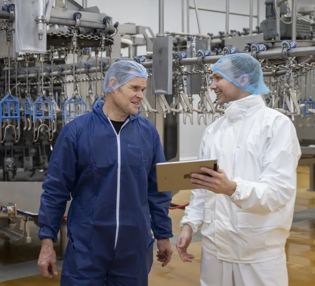 Two colleagues talking on a food plant floor